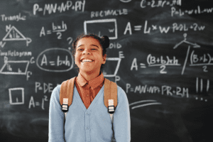 student in front of chalkboard