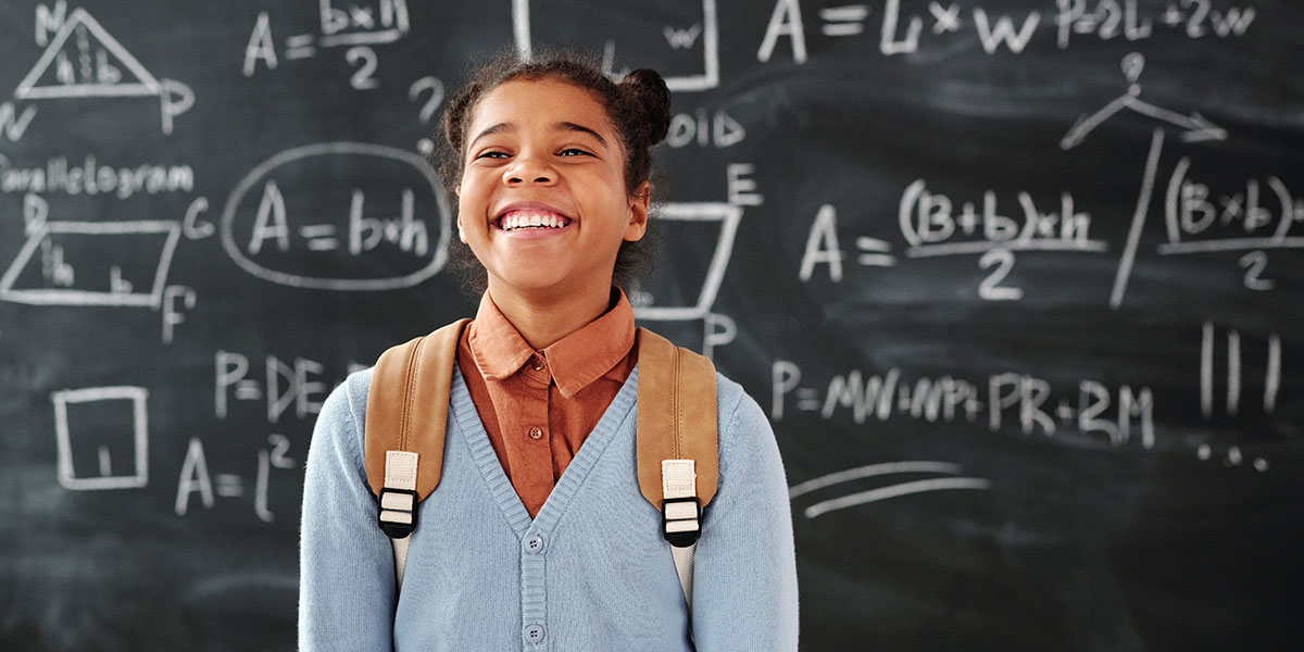 student in front of chalkboard